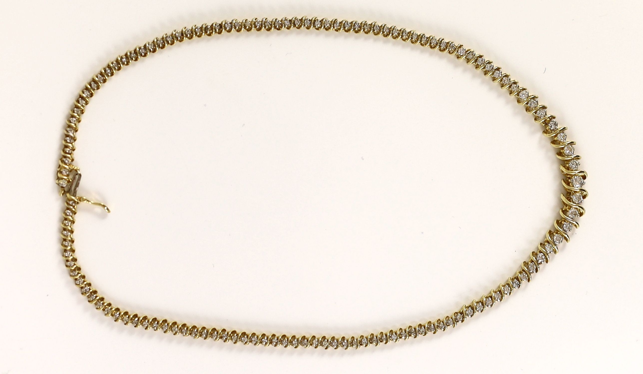 A modern 14k gold and graduated diamond set shaped line necklace